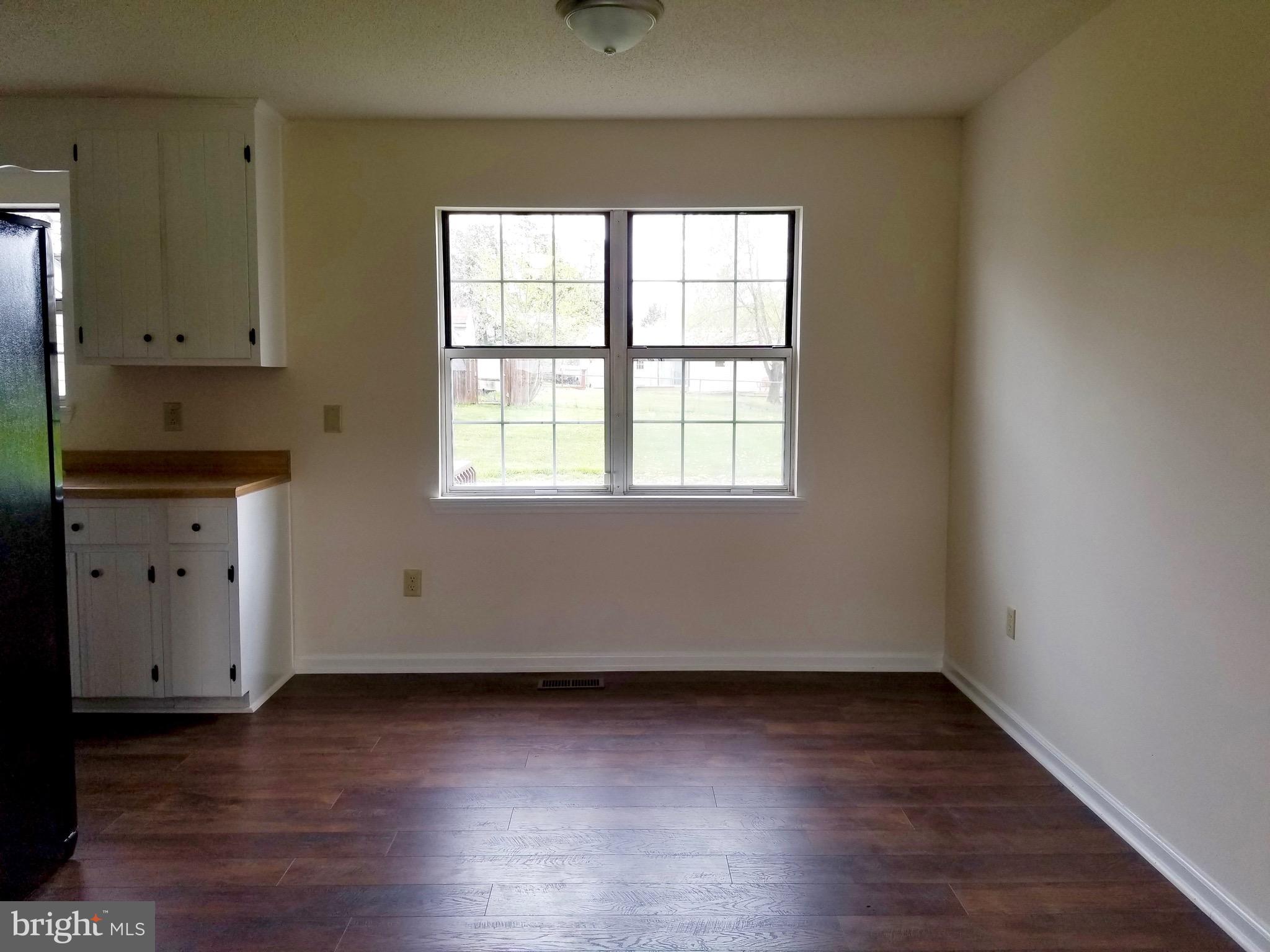 135 Truman Road Inwood, WV 25428 - Photo 7 of 30 an empty room with wooden floor and windows