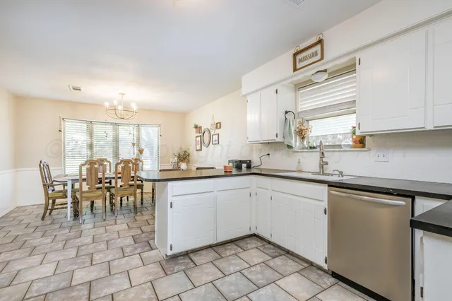 a kitchen with sink cabinets and dining table chair