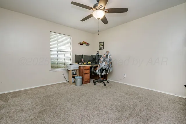 a view of a workspace with furniture and a window