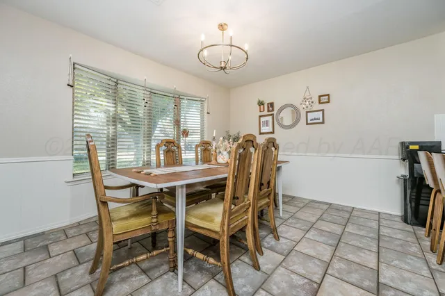 a view of a dining room with furniture and a chandelier