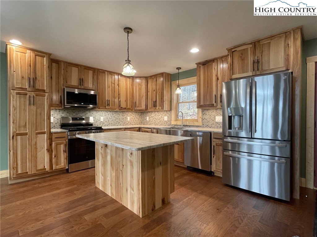 111 Village Cluster Road Beech Mountain, NC 28604 - Photo 11 of 27 a kitchen with a refrigerator a microwave oven and a sink with wooden floor