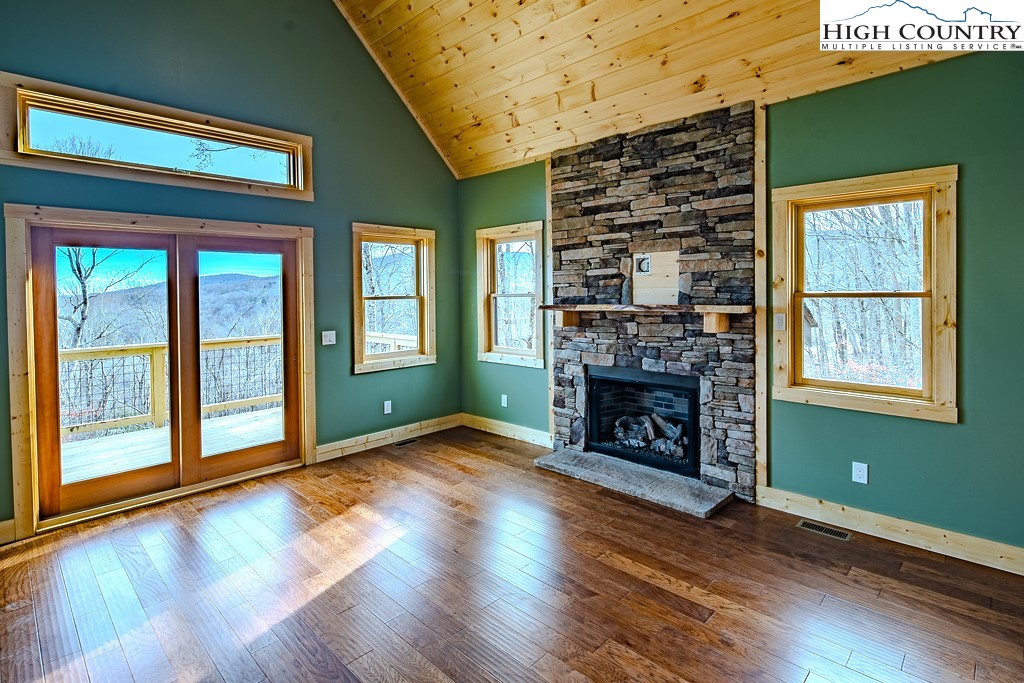 111 Village Cluster Road Beech Mountain, NC 28604 - Photo 3 of 27 a view of an empty room with wooden floor fireplace and a window