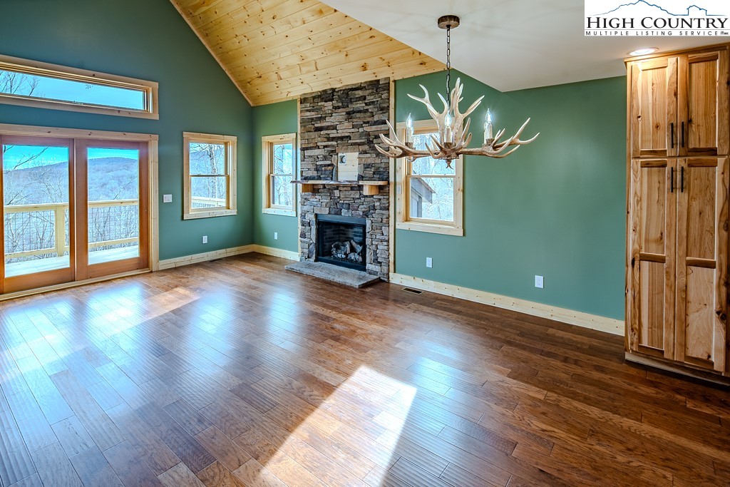 111 Village Cluster Road Beech Mountain, NC 28604 - Photo 4 of 27 wooden floor in an empty room with a fireplace