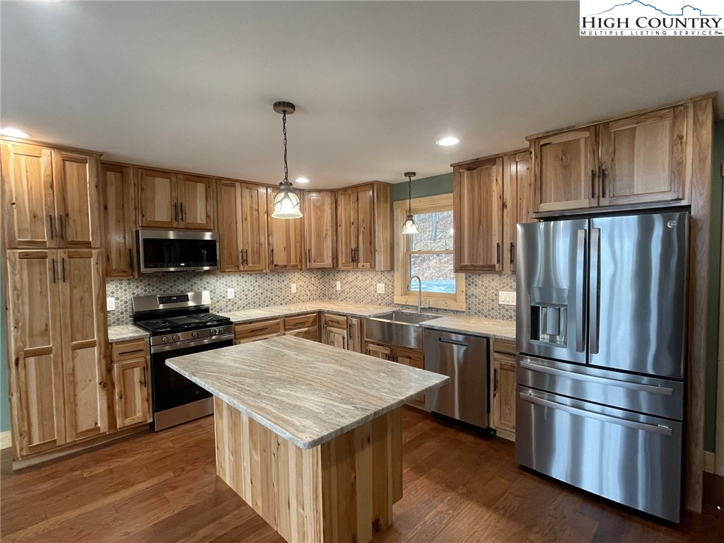 111 Village Cluster Road Beech Mountain, NC 28604 - Photo 6 of 27 a kitchen with kitchen island granite countertop stainless steel appliances and wooden cabinets