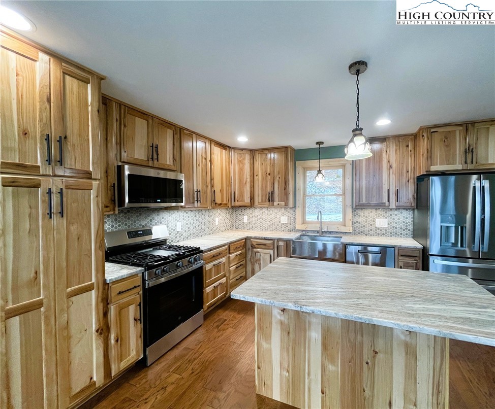 111 Village Cluster Road Beech Mountain, NC 28604 - Photo 7 of 27 a kitchen with stainless steel appliances a stove sink microwave and cabinets