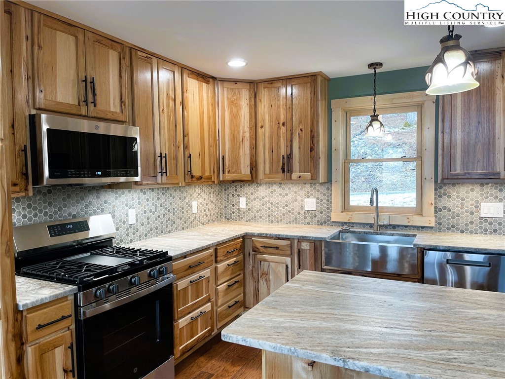 111 Village Cluster Road Beech Mountain, NC 28604 - Photo 8 of 27 a kitchen with stainless steel appliances granite countertop a stove a sink and a microwave