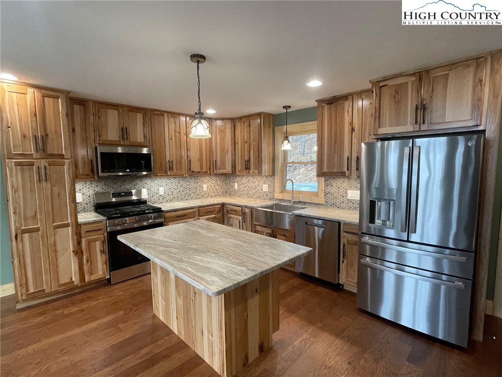 111 Village Cluster Road Beech Mountain, NC 28604 - Photo 9 of 27 a kitchen with a refrigerator a microwave oven and a sink with wooden floor