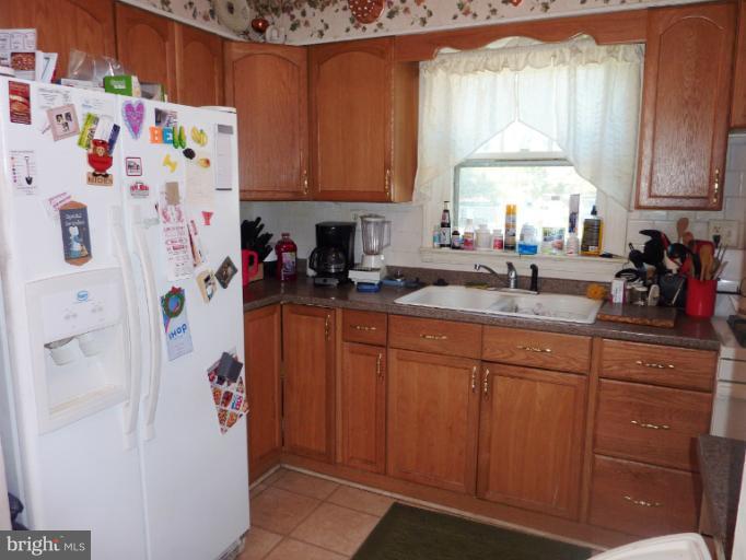 4117 Anderson Road Triangle, VA 22172 - Photo 23 of 30 a kitchen with stainless steel appliances a refrigerator a sink a stove a microwave and cabinets