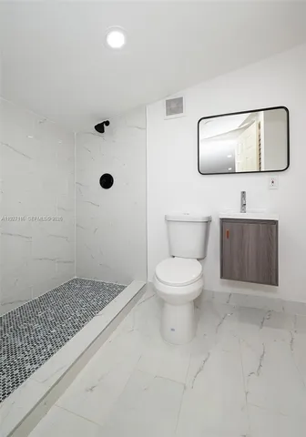 a bathroom with a toilet a sink and mirror