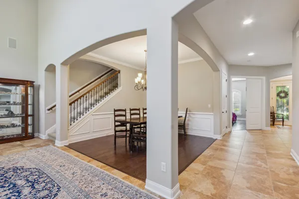 a view of a dining room with furniture a chandelier and wooden floor