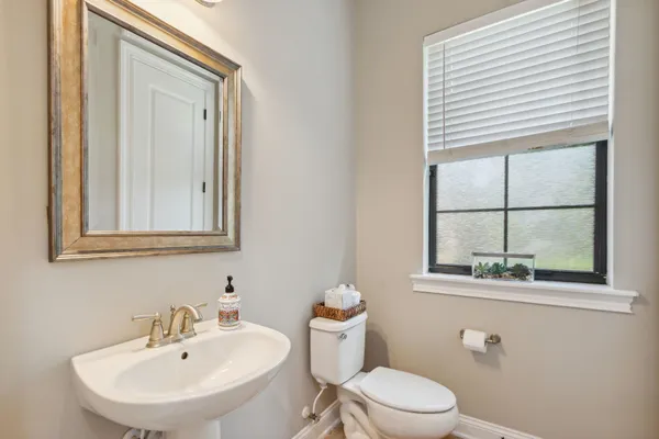 a bathroom with a granite countertop sink a toilet and a mirror