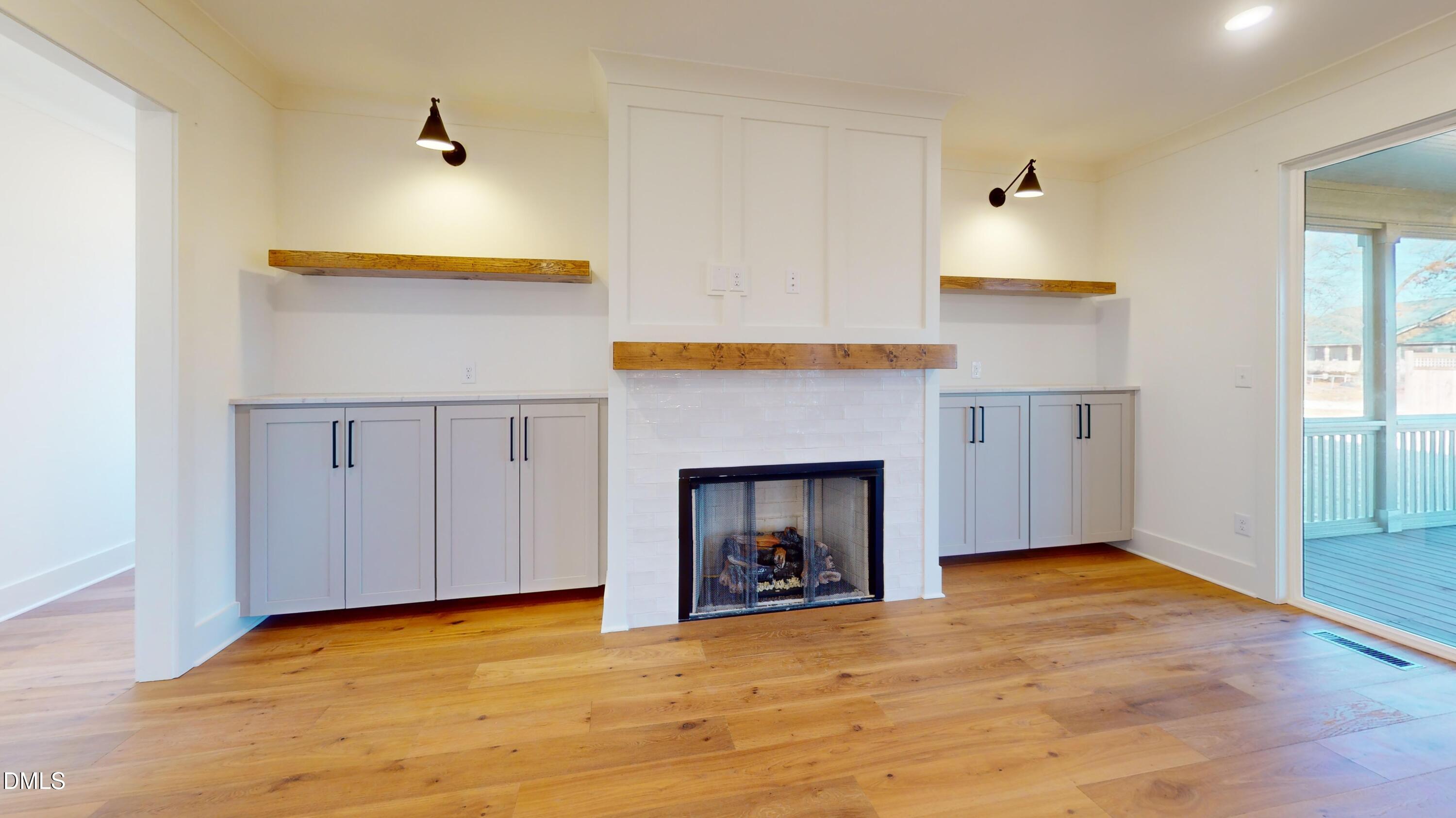5008 Hopkins Chapel Road Zebulon, NC 27597 - Photo 13 of 32 a view of empty room with wooden floor and fireplace