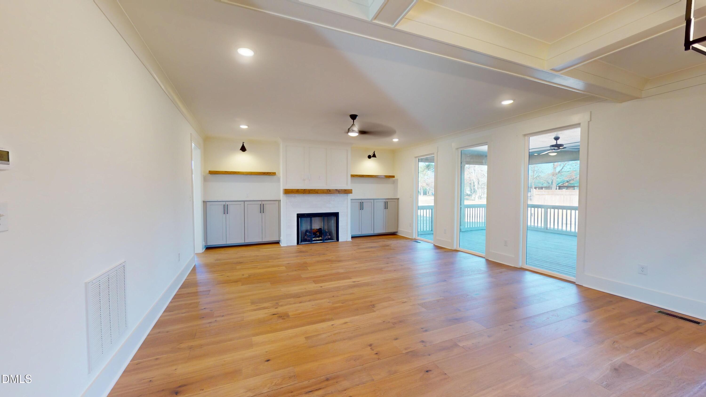 5008 Hopkins Chapel Road Zebulon, NC 27597 - Photo 15 of 32 an empty room with wooden floor and windows