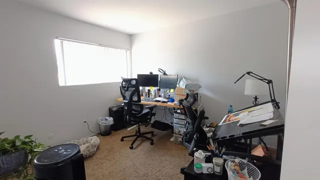 a view of a workspace with furniture and a window