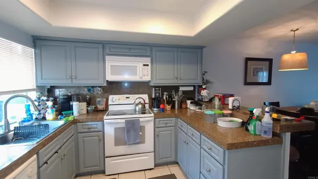 a kitchen with stainless steel appliances granite countertop a sink a stove and cabinets