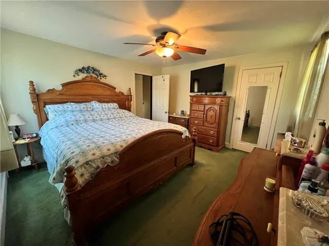 a bedroom with a bed and flat tv screen on dresser