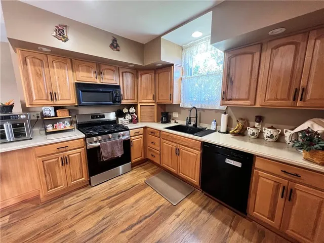 a kitchen with granite countertop a sink cabinets and stainless steel appliances