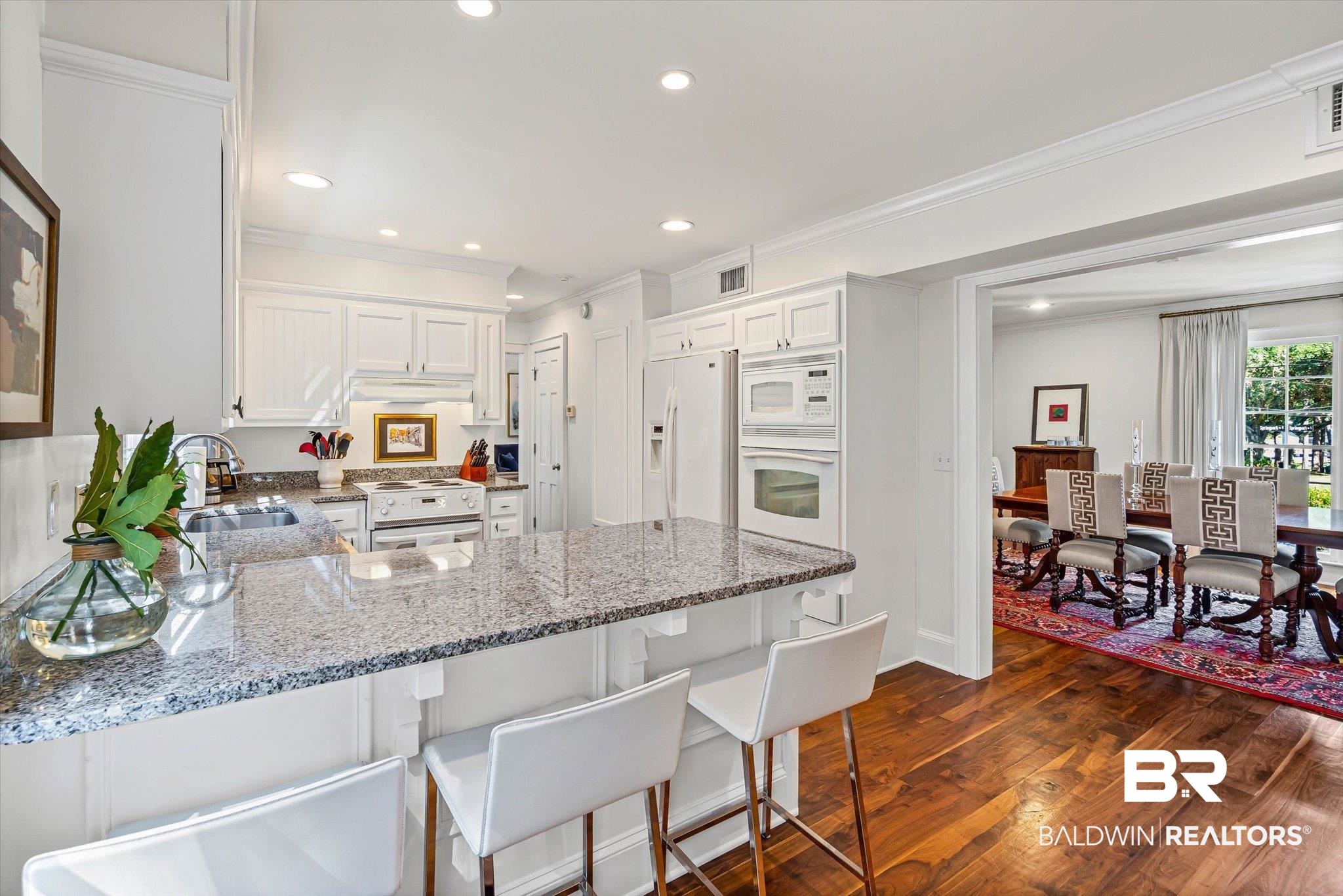 513 Spring Park Drive East Mobile, AL 36608 - Photo 9 of 44 Kitchen with white cabinets, light stone countertops, dark wood-type flooring, a peninsula, and crown molding