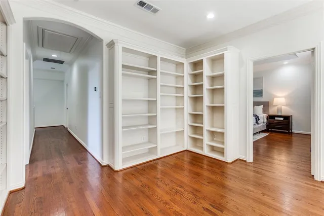 a view of empty room with wooden floor and cabinet