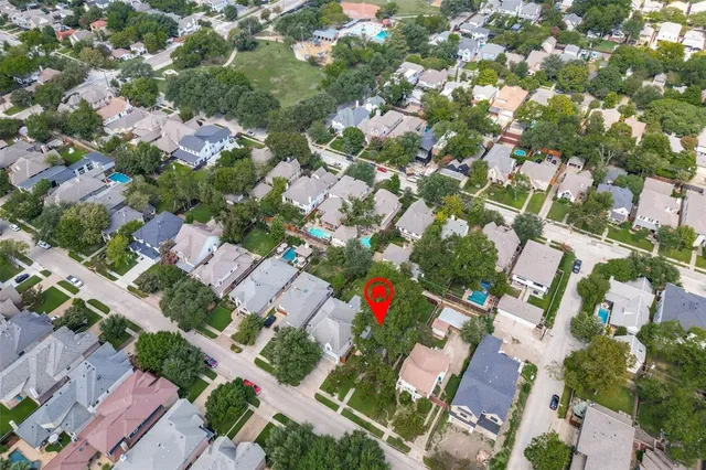 an aerial view of residential houses with outdoor space and trees