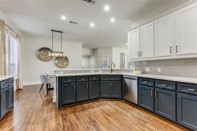 a kitchen with a sink cabinets and wooden floor