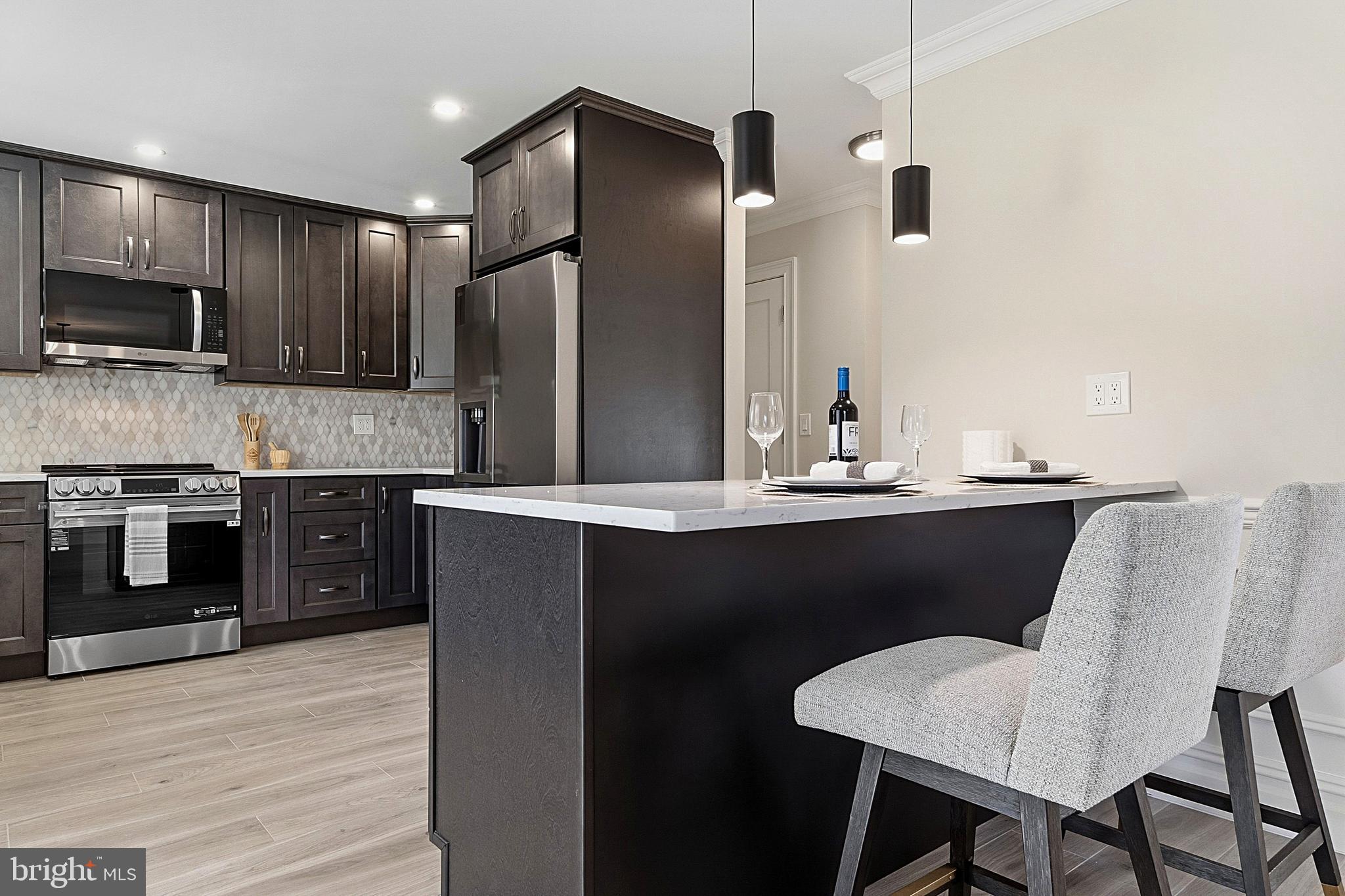 780 Ardmore Road Monroe Township, NJ 08831 - Photo 8 of 30 a kitchen with stainless steel appliances kitchen island granite countertop a table chairs microwave and sink