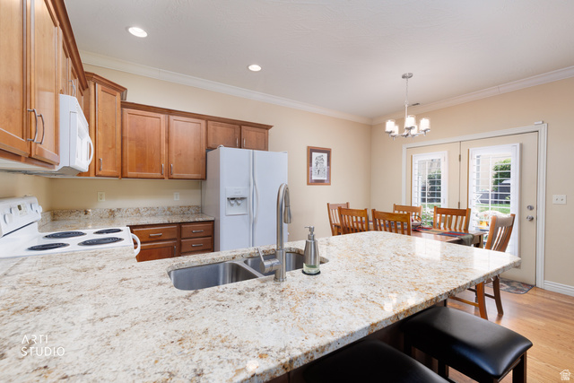 6761 950 East Midvale, UT 84047 - Photo 15 of 44 Kitchen island with a stainless steel undermount sink, granite countertop, recessed lighting, and wood-finish flooring