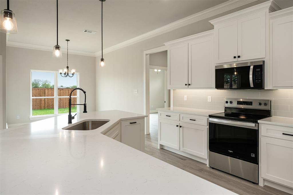 509 Limestone Circle Mabank, TX 75147 - Photo 13 of 36 a kitchen with a sink a stove and microwave