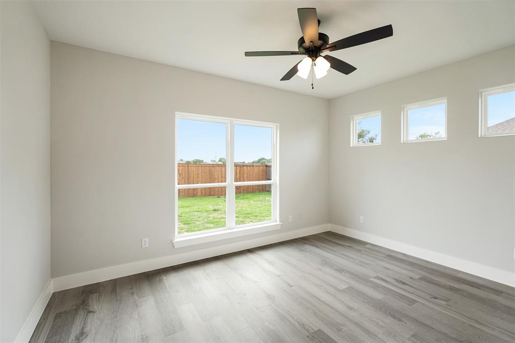 509 Limestone Circle Mabank, TX 75147 - Photo 23 of 36 an empty room with wooden floor chandelier fan and windows