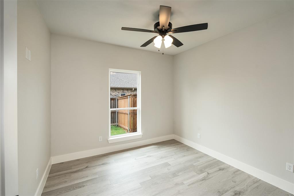 509 Limestone Circle Mabank, TX 75147 - Photo 24 of 36 an empty room with wooden floor chandelier fan and windows