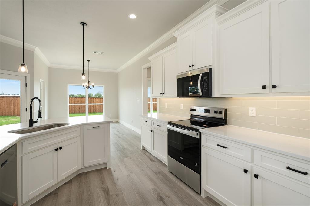 509 Limestone Circle Mabank, TX 75147 - Photo 10 of 36 a kitchen with granite countertop white cabinets and stainless steel appliances