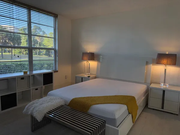 a bedroom with a bed next to a window