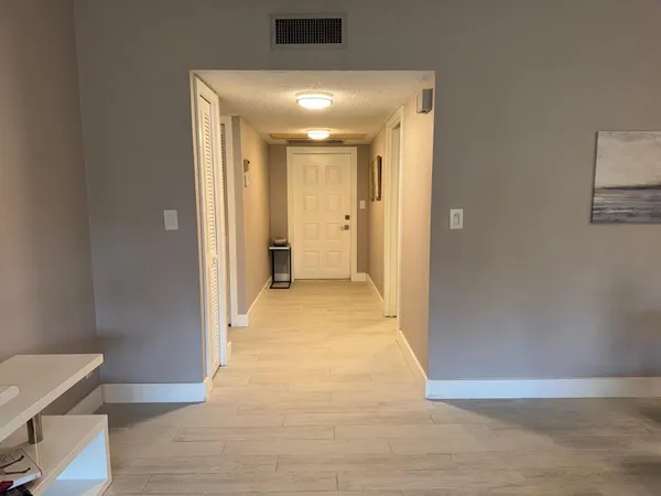 a view of a hallway with wooden floor