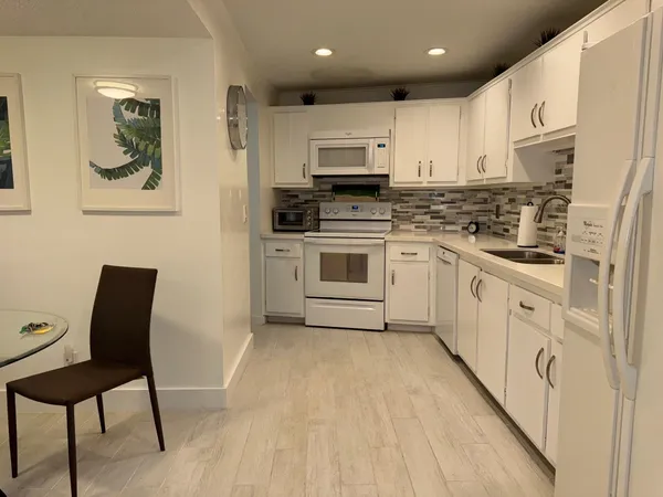 a kitchen with cabinets and chairs