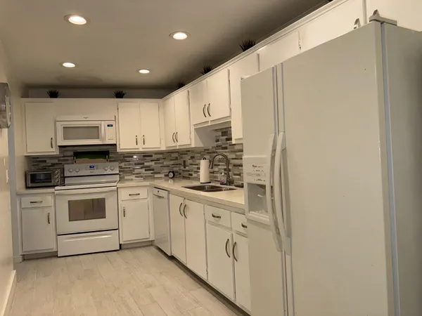 a kitchen with stainless steel appliances granite countertop white cabinets stove a sink and dishwasher