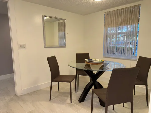a view of a dining room with furniture and a window