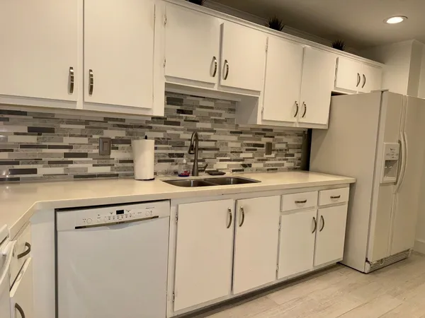 a kitchen with appliances a sink and cabinets