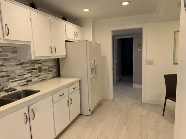 a kitchen with stainless steel appliances a refrigerator sink and cabinets