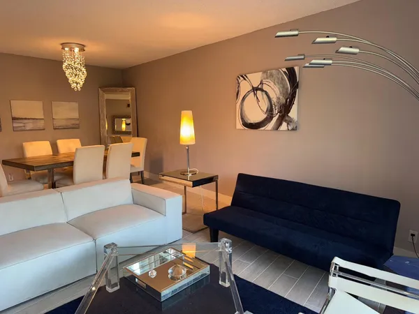 a living room with furniture and a chandelier