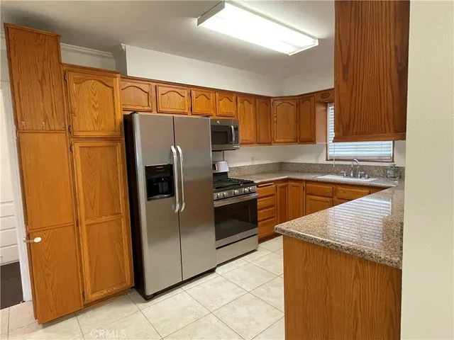 a kitchen with stainless steel appliances granite countertop a refrigerator and a sink