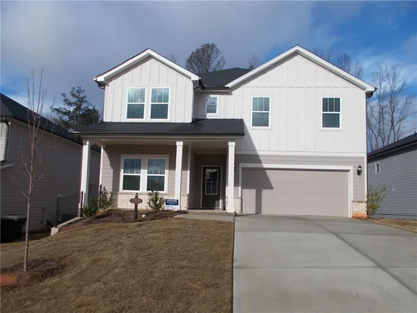 a view of a white house with large windows and potted plants