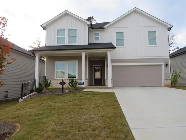 a front view of house with yard outdoor seating and garage