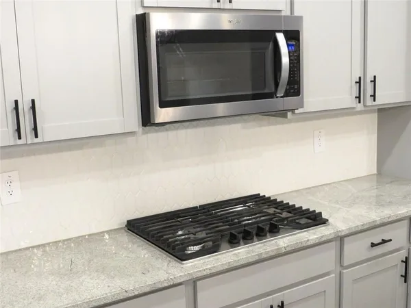 a stove top oven sitting inside of a kitchen