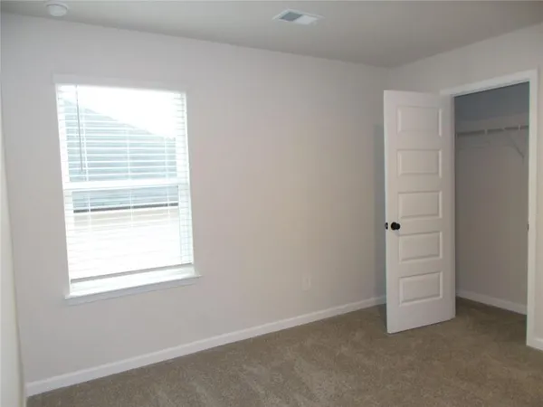 an empty room with windows and closet