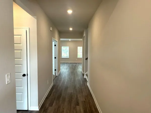 a view of a hallway with wooden floor and staircase