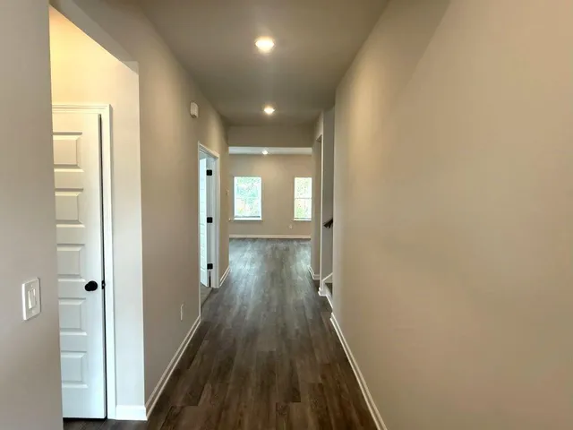 a view of a hallway with wooden floor and staircase
