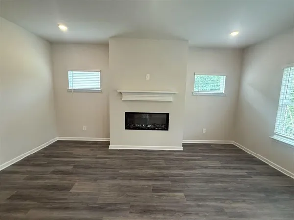 an empty room with wooden floor and a window