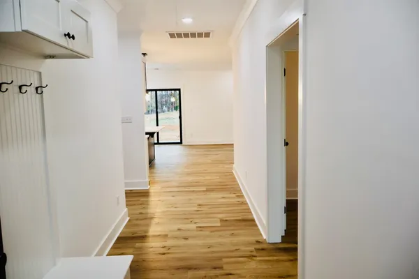 a view of a hallway with wooden floor and staircase