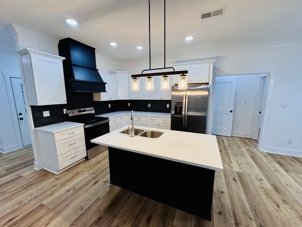 a view of a hallway with wooden floor and entryway