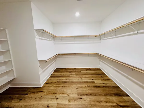 a view of a kitchen with white cabinets and wooden floor
